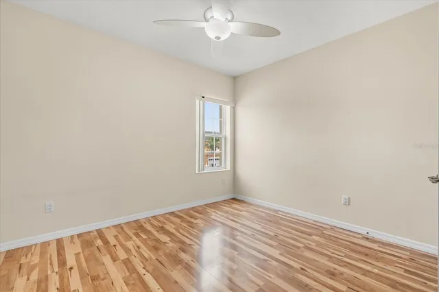a view of a room with wooden floor and a ceiling fan