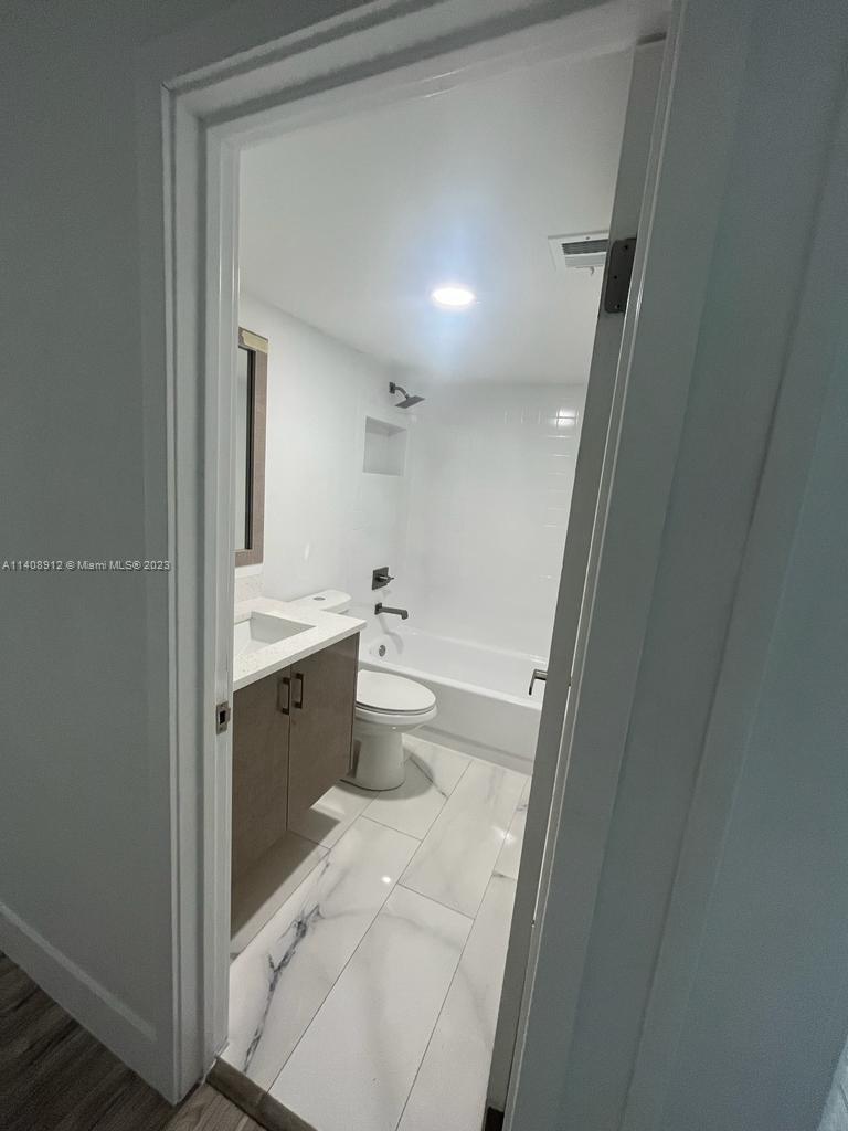 Heathgate Street Tamarac, FL 33321 - Photo 13 of 23 a bathroom with a sink a toilet a shower and a mirror