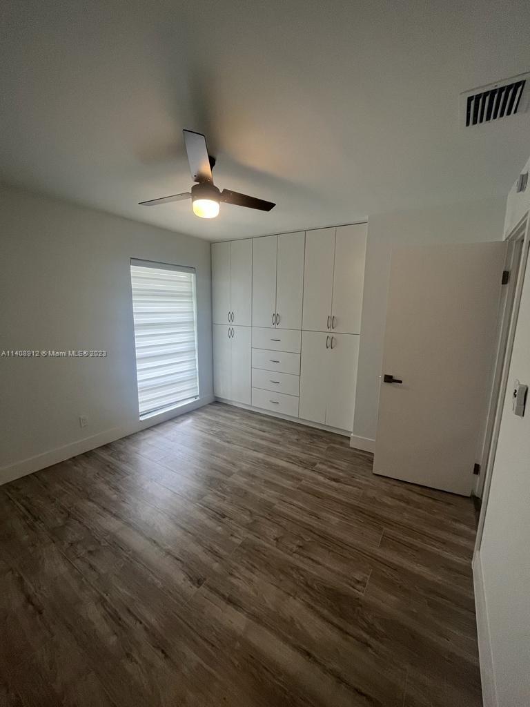 Heathgate Street Tamarac, FL 33321 - Photo 17 of 23 an empty room with wooden floor chandelier fan and windows