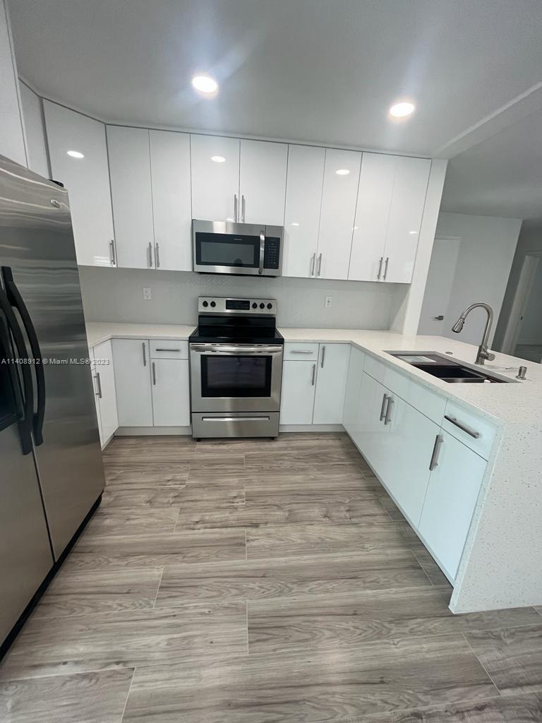 Heathgate Street Tamarac, FL 33321 - Photo 4 of 23 a kitchen with granite countertop a sink stainless steel appliances and cabinets