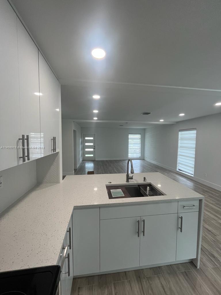 Heathgate Street Tamarac, FL 33321 - Photo 5 of 23 a kitchen with kitchen island granite countertop a sink and white cabinets