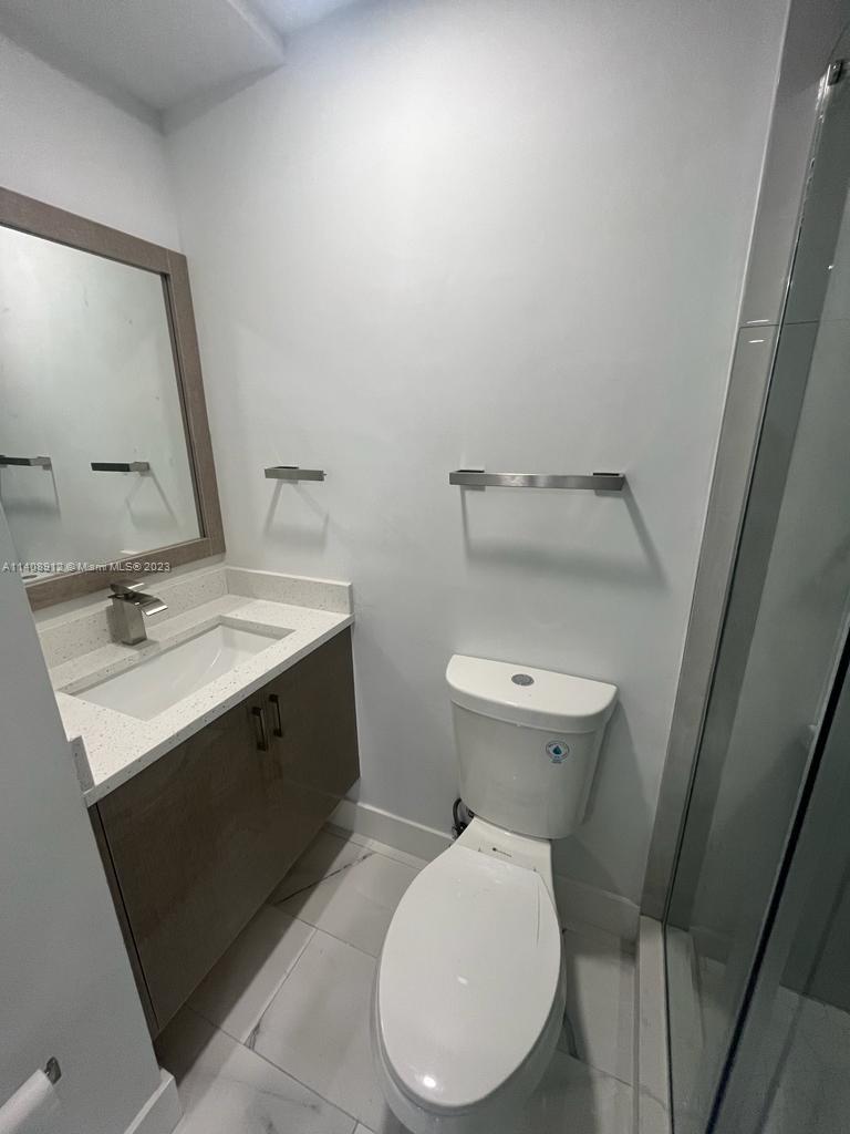 Heathgate Street Tamarac, FL 33321 - Photo 8 of 23 a bathroom with a toilet sink and mirror