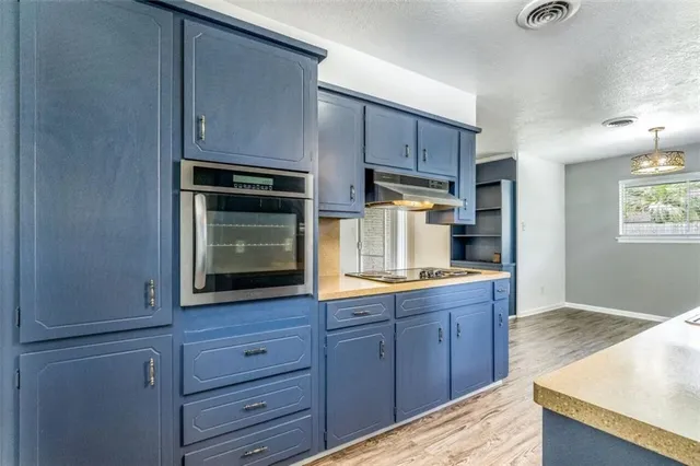 a kitchen with wooden cabinets and stove