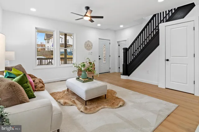 a kitchen with stainless steel appliances granite countertop a refrigerator a stove a sink dishwasher and white cabinets with wooden floor