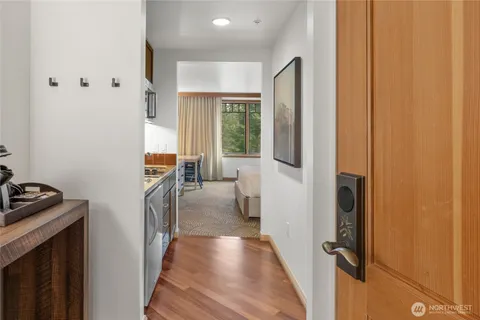 a hallway with wooden floor windows and a livingroom