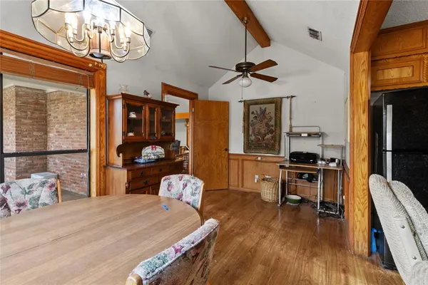 a bedroom with a bed a chandelier and flat screen tv