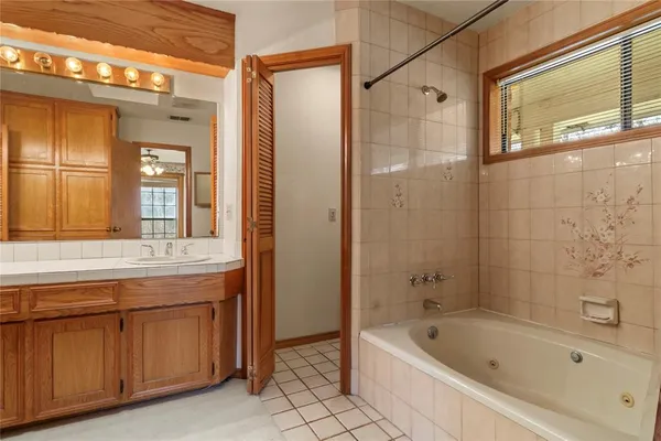 a bathroom with a tub a sink and a large mirror