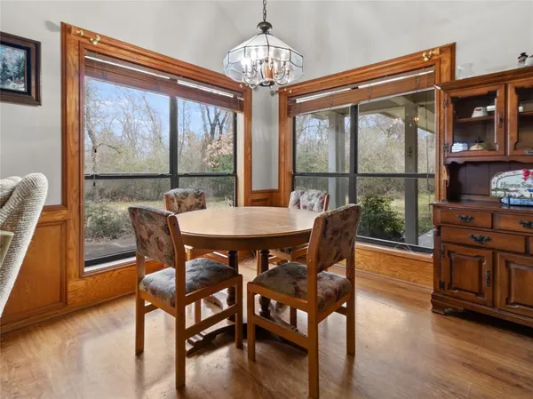 a view of a dining room with furniture large window wooden floor and a chandelier