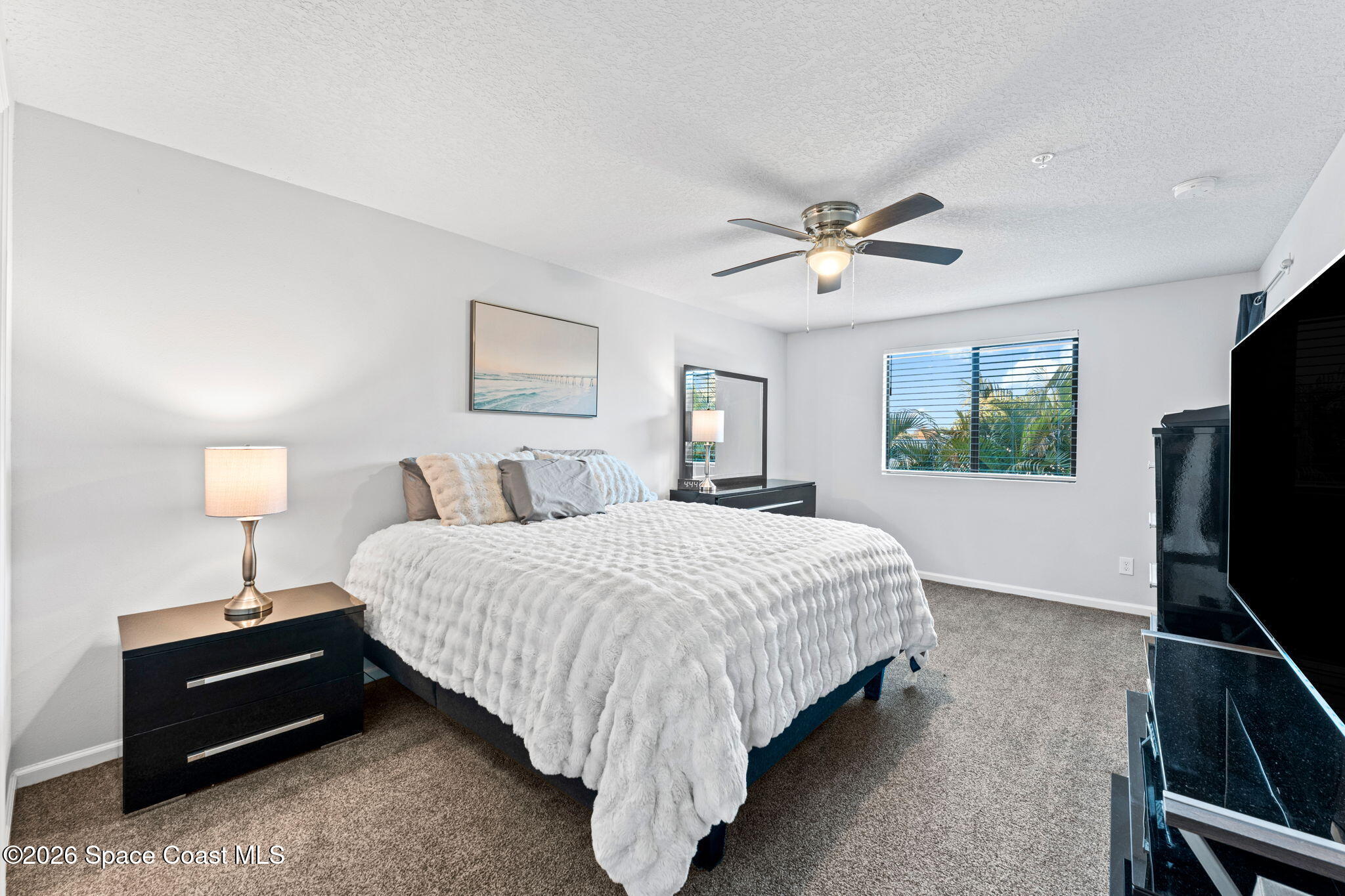 1415 Lara Circle, Unit 106 Rockledge, FL 32955 - Photo 25 of 42 a spacious bedroom with a bed and a flat screen tv