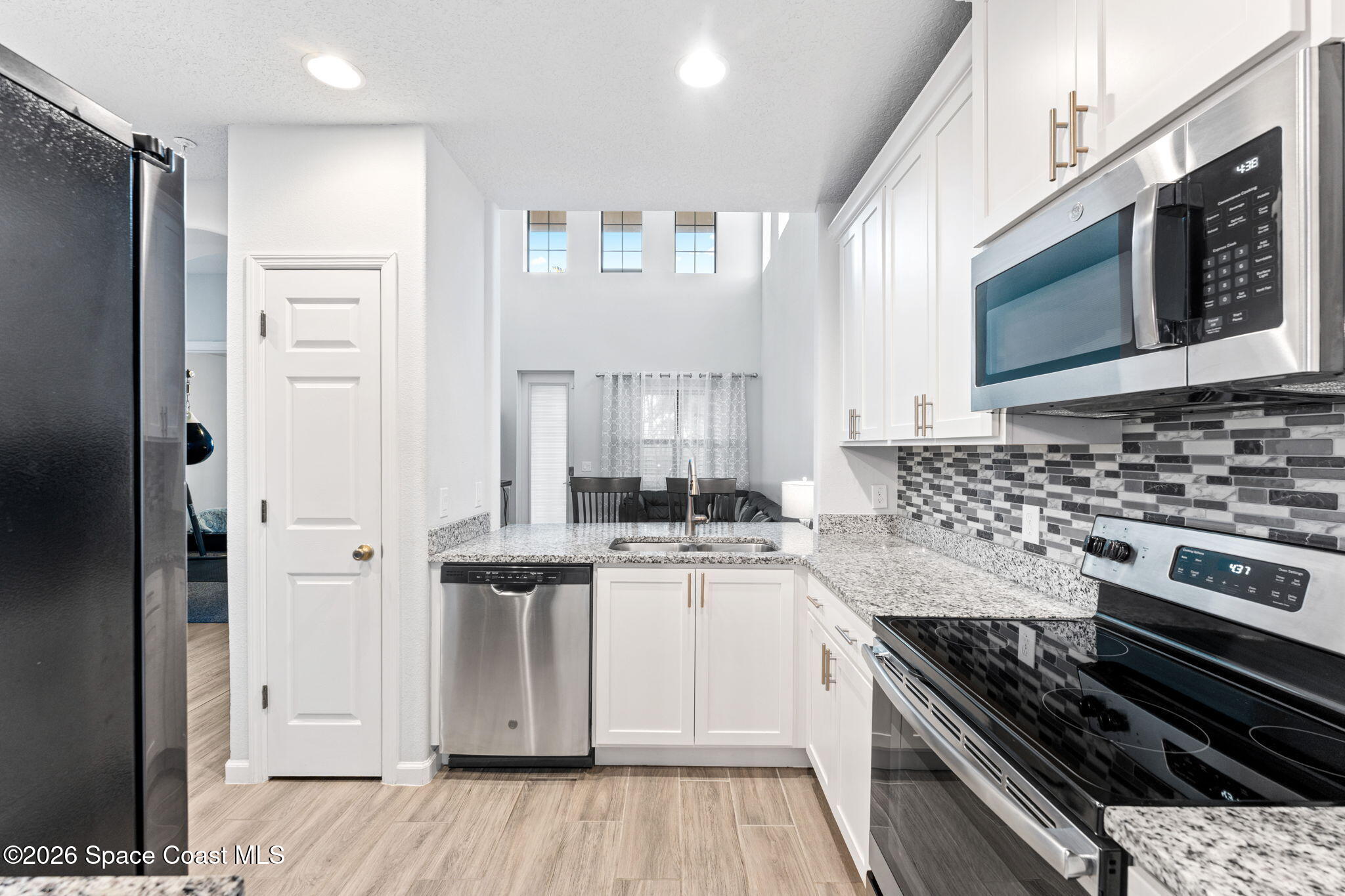 1415 Lara Circle, Unit 106 Rockledge, FL 32955 - Photo 9 of 42 a kitchen with stainless steel appliances granite countertop a stove and a refrigerator