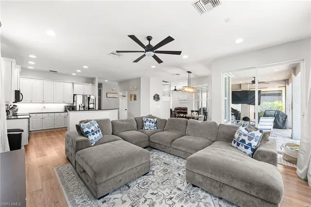 a living room with furniture kitchen view and a chandelier