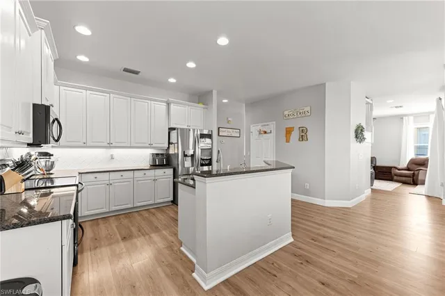 a kitchen with refrigerator and cabinets