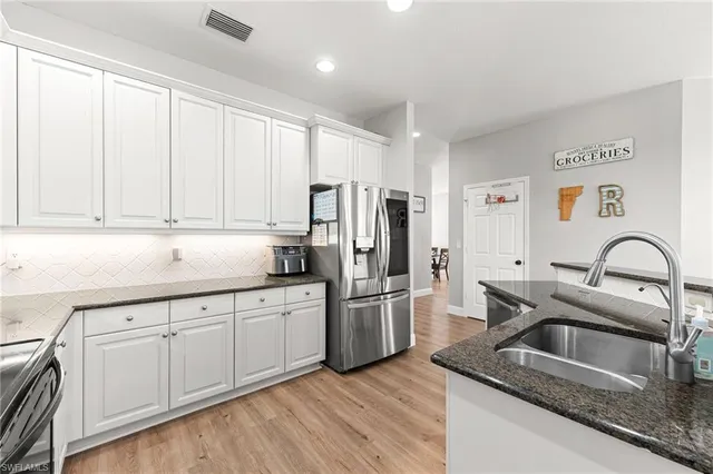 a kitchen with stainless steel appliances granite countertop a refrigerator sink and cabinets