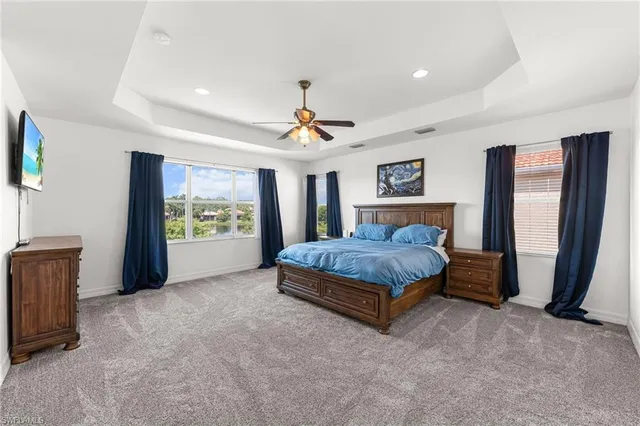 a spacious bedroom with a large bed and a chandelier