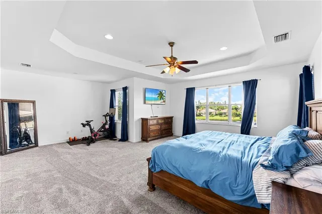 a bedroom with a bed and large windows