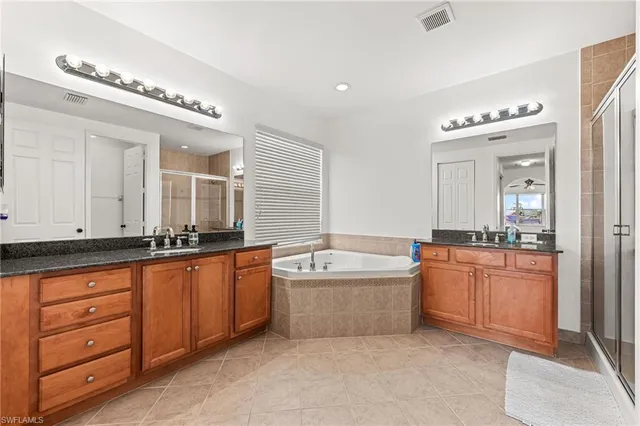 a spacious bathroom with a granite countertop tub sink and mirror