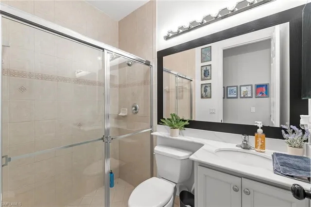 a bathroom with a granite countertop sink toilet a mirror and shower