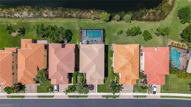 an aerial view of a residential apartment building with a yard and parking spaces