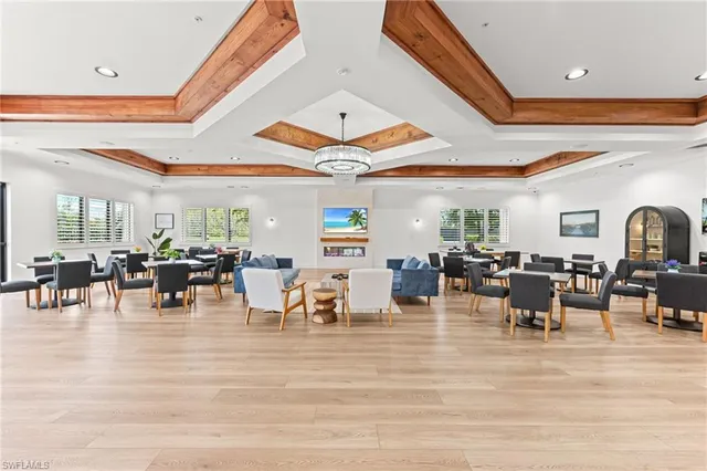 a room with lots of tables a large window and chairs