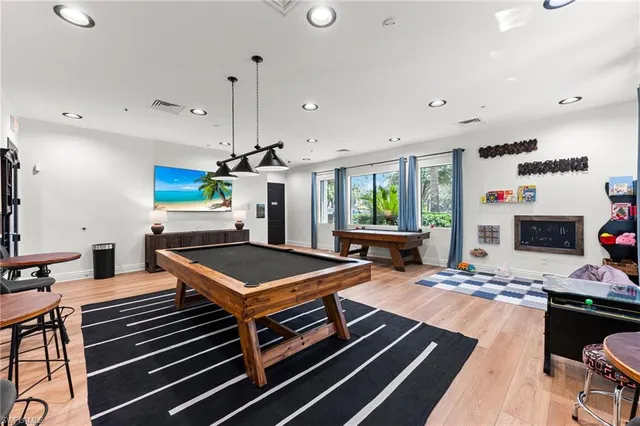 a room with furniture a pool table and a window