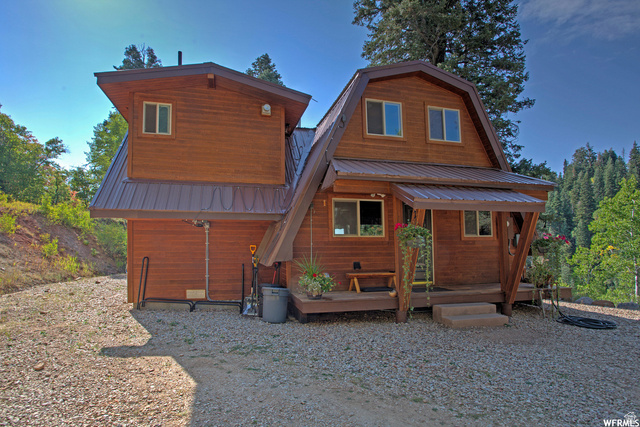 1644 West Tollgate Cyn Road, Unit 79AM Coalville, UT 84017 - Photo 31 of 31 Wood-sided dwelling with a brown metal roof, featuring multiple windows and an inviting covered porch