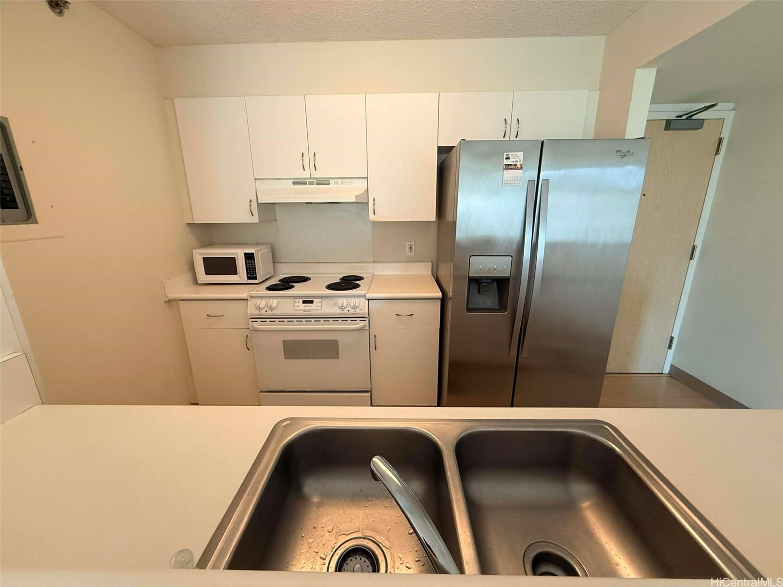 1448 Young Street, Unit 501 Honolulu, HI 96814 - Photo 4 of 17 a kitchen with a refrigerator sink and cabinets