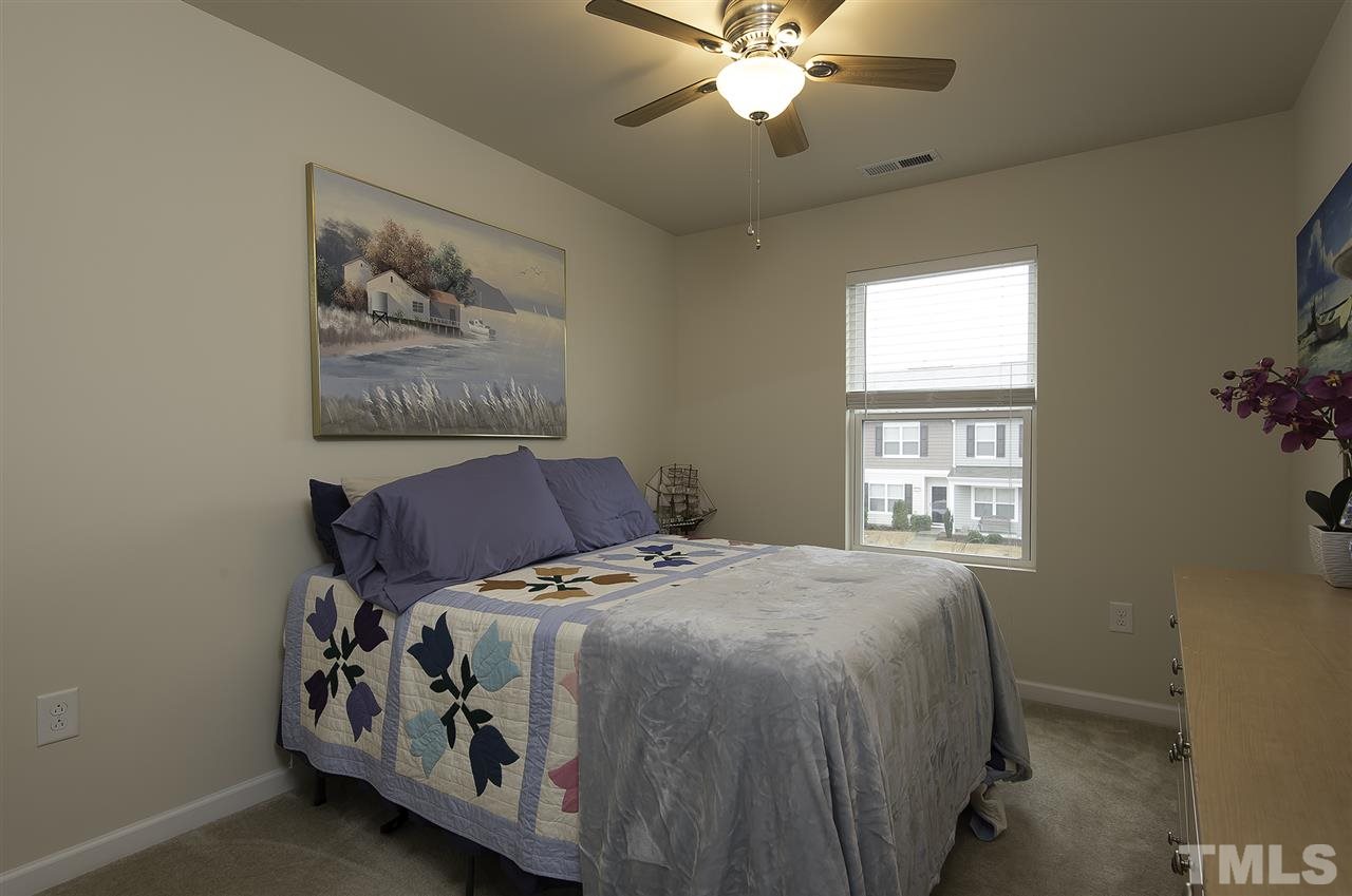 2912 Berkeley Springs Place Raleigh, NC 27616 - Photo 14 of 19 a bed sitting in a bedroom next to a window