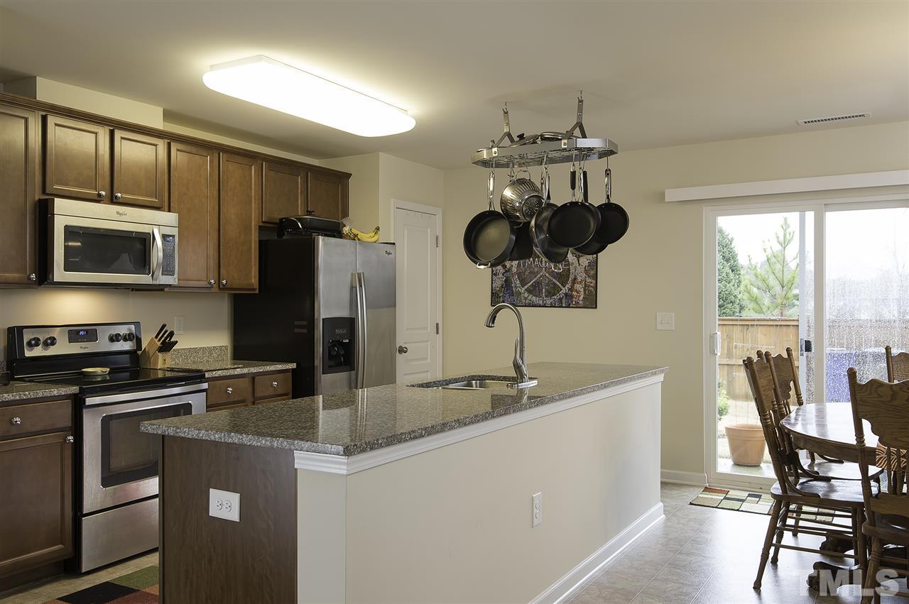 2912 Berkeley Springs Place Raleigh, NC 27616 - Photo 8 of 19 a kitchen with stainless steel appliances granite countertop a sink a stove a microwave a refrigerator and cabinets