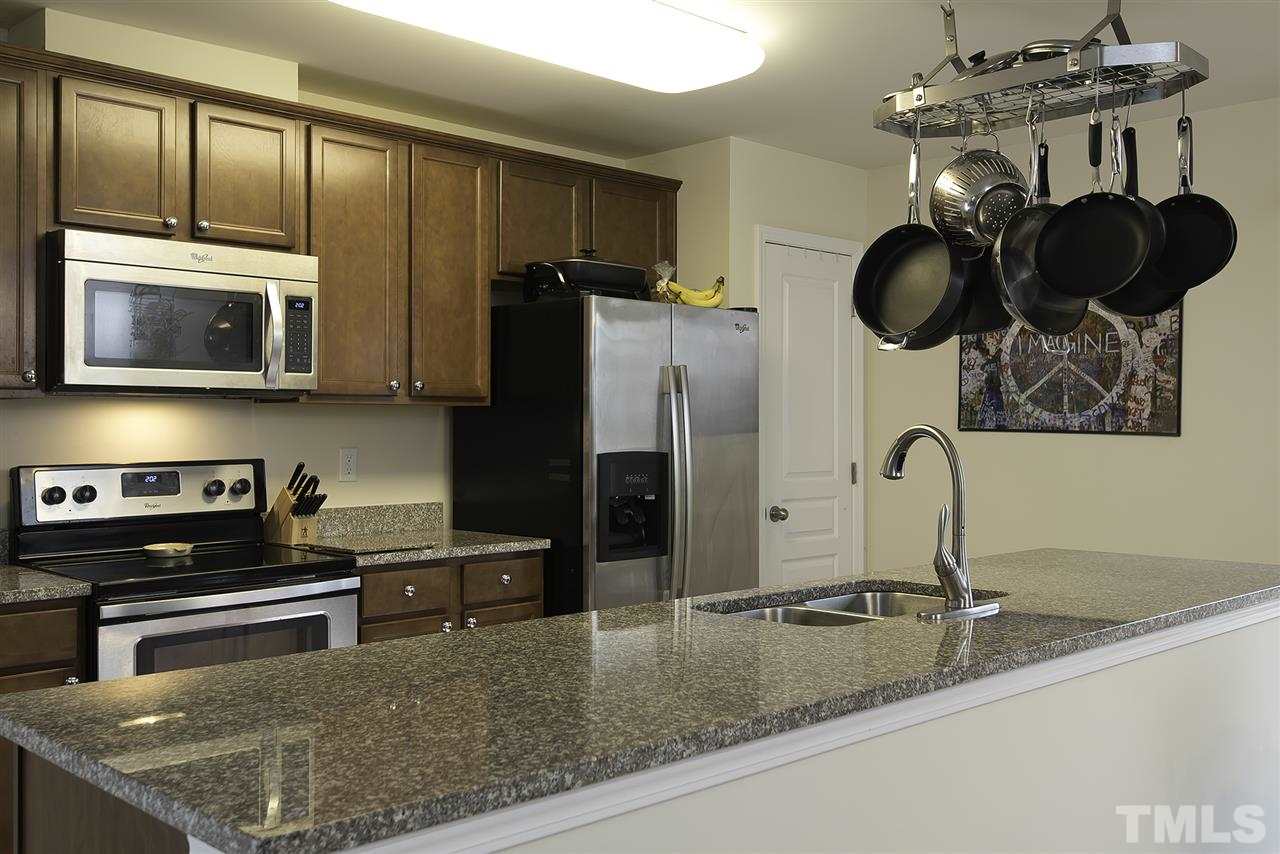 2912 Berkeley Springs Place Raleigh, NC 27616 - Photo 9 of 19 a kitchen with stainless steel appliances granite countertop a sink stove and refrigerator