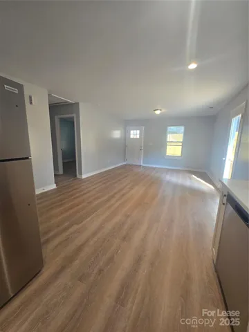 a view of an empty room and window and wooden floor