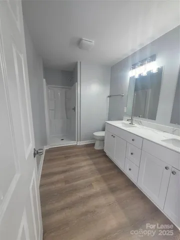 a spacious bathroom with a double vanity sink a mirror and a shower