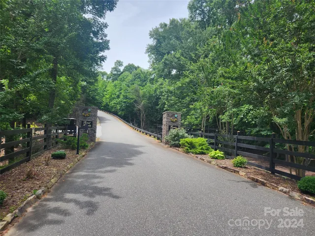 a view of a dirt road with trees in the background