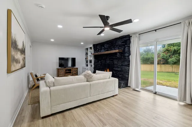 a living room with furniture a flat screen tv and a fireplace
