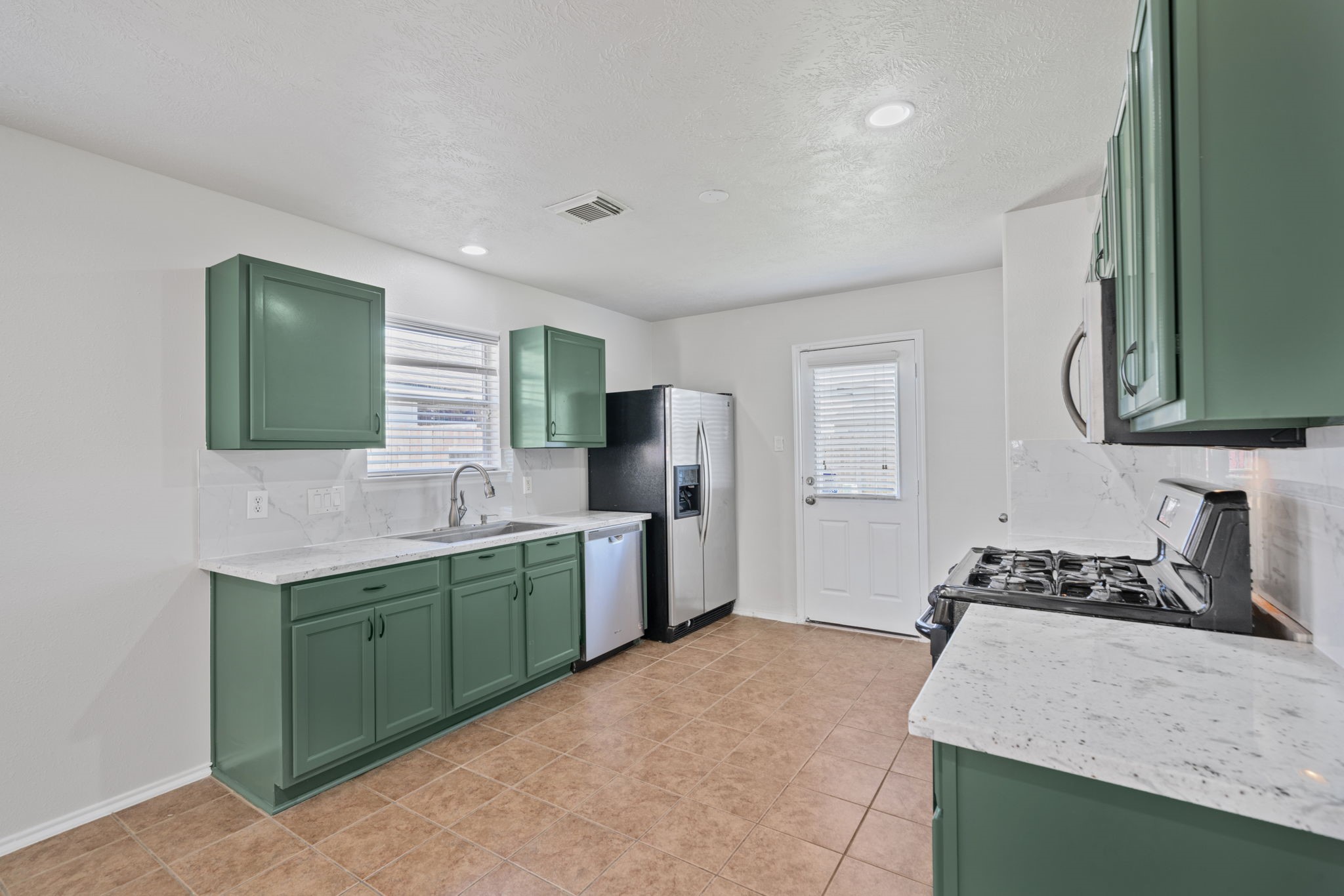 14323 Brunswick Point Lane Houston, TX 77047 - Photo 12 of 33 a kitchen with a sink stove and refrigerator