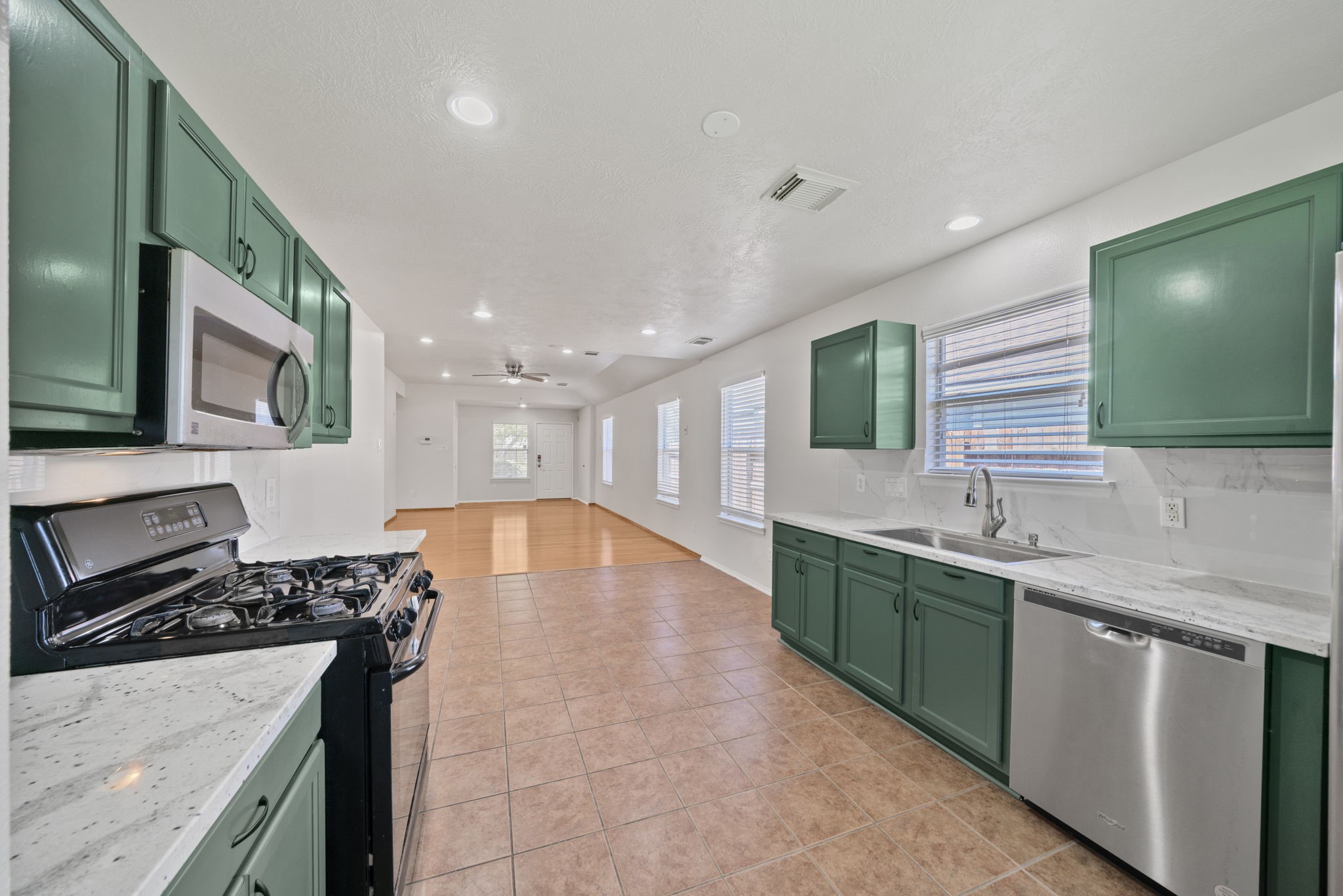 14323 Brunswick Point Lane Houston, TX 77047 - Photo 13 of 33 a kitchen with stainless steel appliances granite countertop a sink and a stove top oven with wooden floor