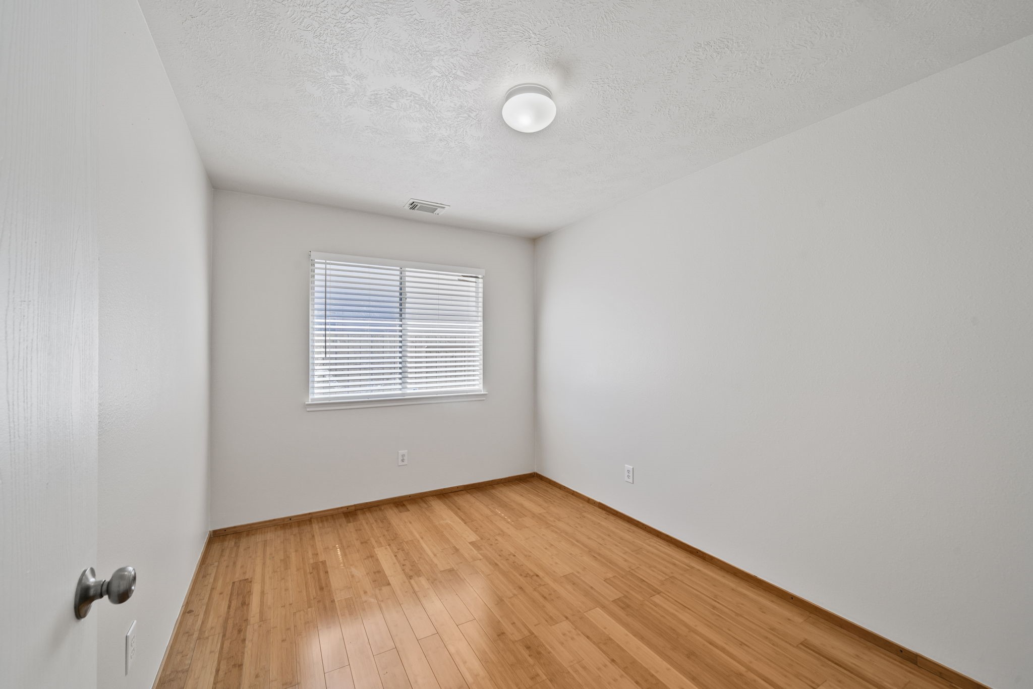 14323 Brunswick Point Lane Houston, TX 77047 - Photo 22 of 33 a view of an empty room with wooden floor and a window