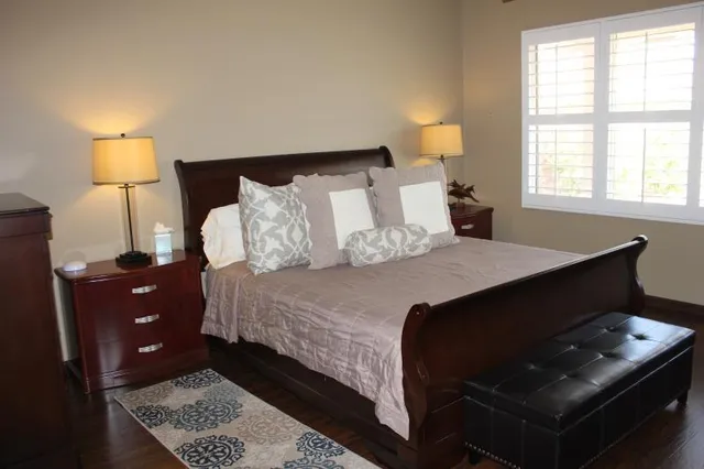 a bedroom with a bed and a lamp on dresser