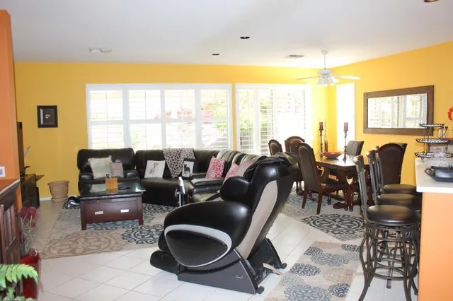 a living room with furniture a flat screen tv and a floor to ceiling window