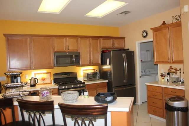 a kitchen with a refrigerator and a stove top oven