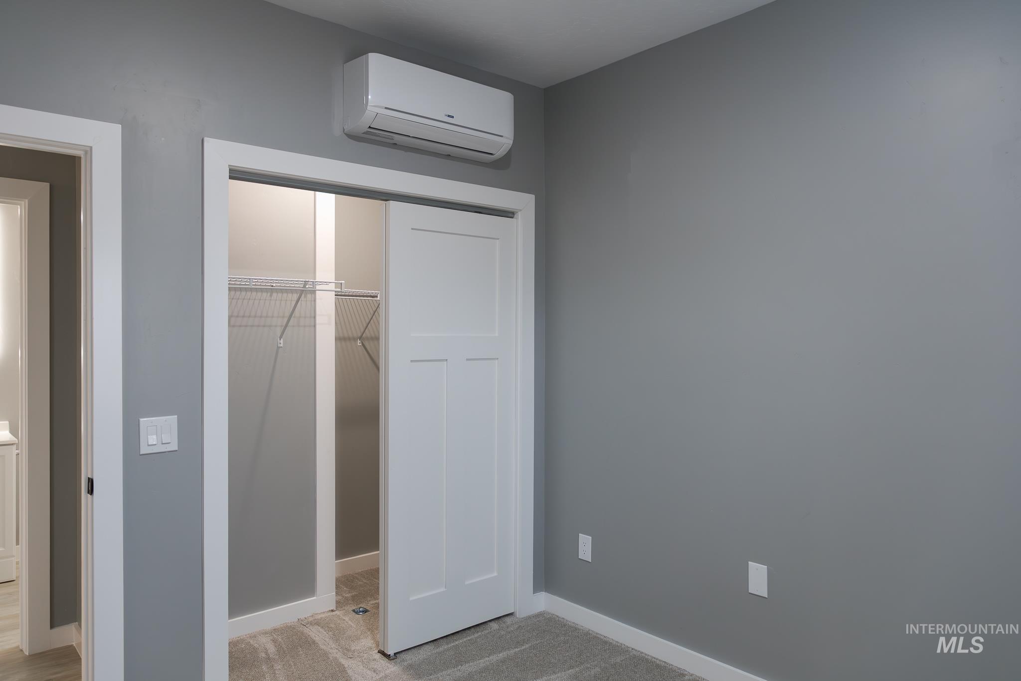 287 Southwest 6th Street, Unit 2 Ontario, OR 97914 - Photo 12 of 37 Unfurnished bedroom featuring a wall mounted mini split, a closet, and light colored carpet