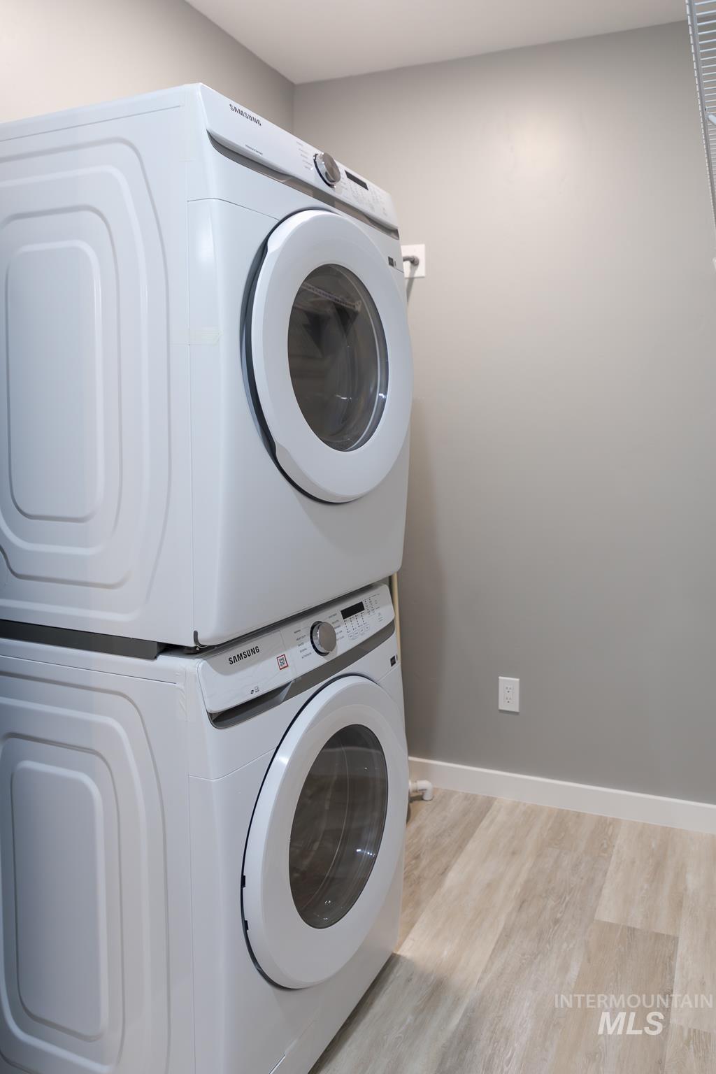 287 Southwest 6th Street, Unit 2 Ontario, OR 97914 - Photo 21 of 37 Laundry area featuring light wood-style flooring and stacked washing machine and dryer