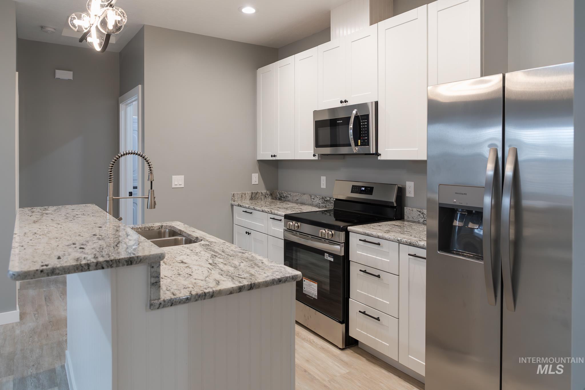 287 Southwest 6th Street, Unit 2 Ontario, OR 97914 - Photo 5 of 37 Kitchen featuring stainless steel appliances, light stone counters, and white cabinets
