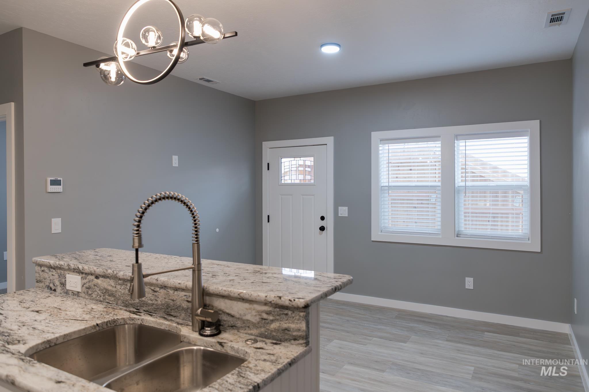 287 Southwest 6th Street, Unit 2 Ontario, OR 97914 - Photo 7 of 37 Kitchen featuring light stone counters, suspended lighting, and light wood-style flooring