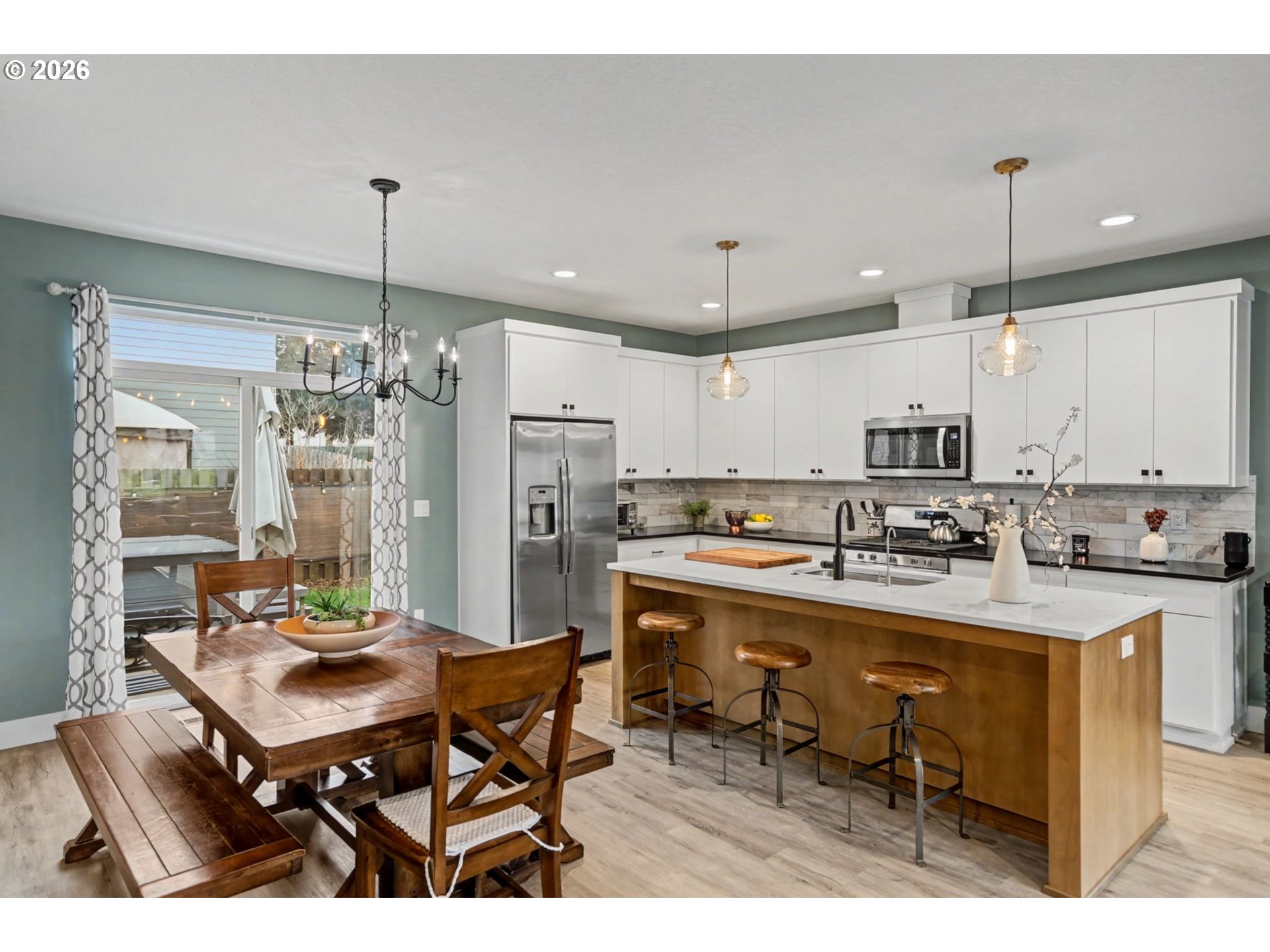 5520 Crossler Meadow Loop South Salem, OR 97306 - Photo 13 of 40 a kitchen with stainless steel appliances kitchen island granite countertop a dining table chairs stove refrigerator and cabinets