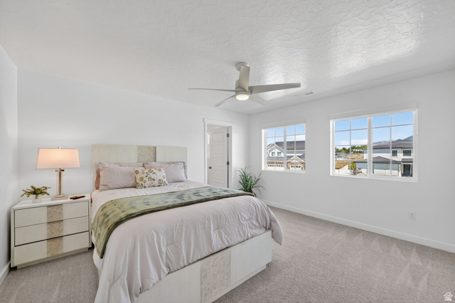 1165 West Union Bench Drive Mapleton, UT 84664 - Photo 28 of 61 Bright bedroom with two large windows, a ceiling fan, and grey carpet flooring