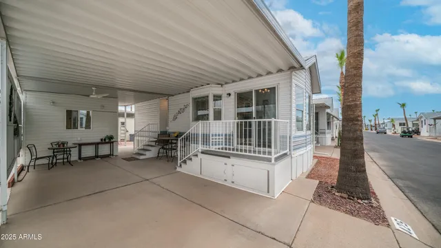 a roof deck with table and chairs and potted plants