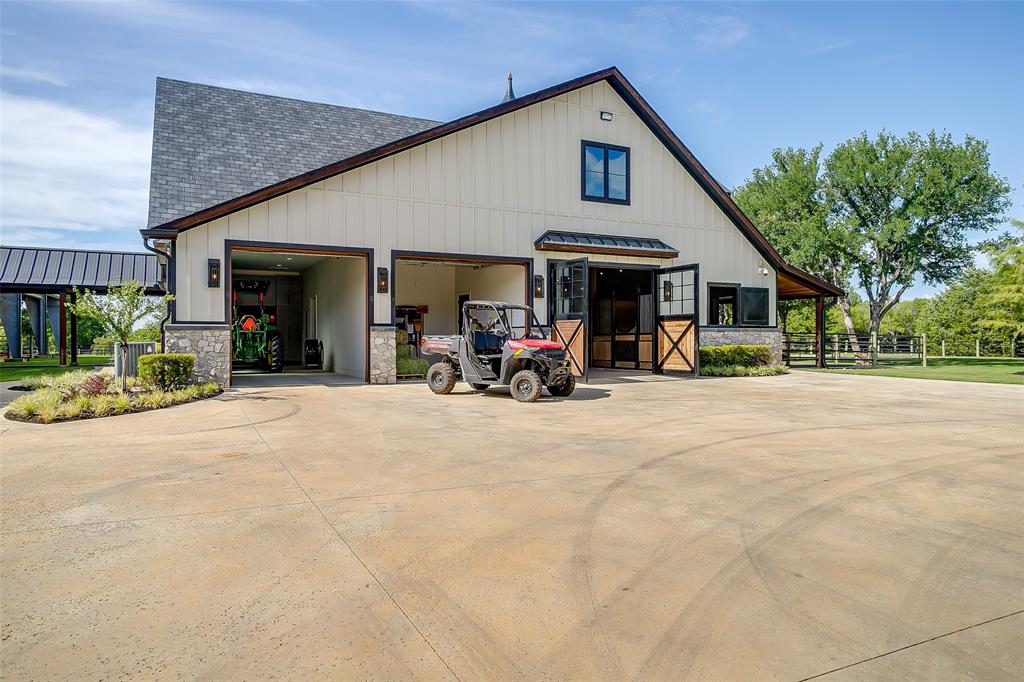 5000 T W King Road Southlake, TX 76092 - Photo 29 of 40 Oversized roll-up doors provide easy access for equipment and storage, seamlessly connecting to the barn alley.