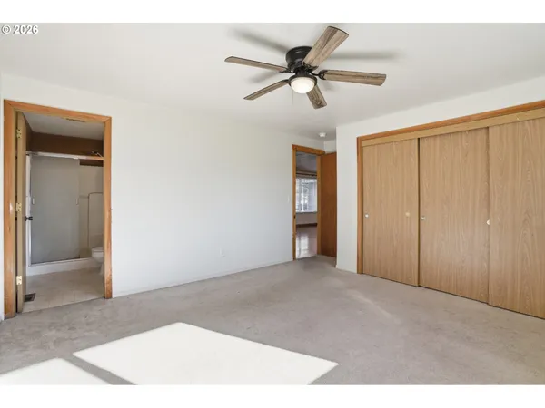 a view of a livingroom with a ceiling fan & entryway