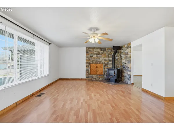 a view of an empty room with a window and fireplace