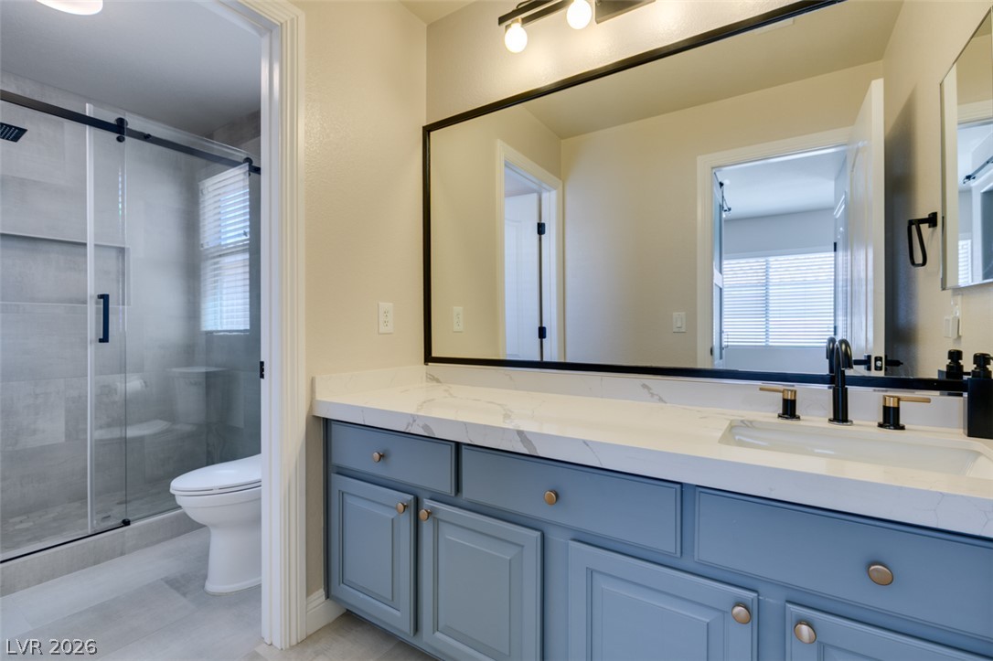 8909 Houston Ridge Avenue Las Vegas, NV 89178 - Photo 32 of 45 A well-appointed bathroom features a single vanity with a marble countertop, modern fixtures, and a spacious walk-in shower.